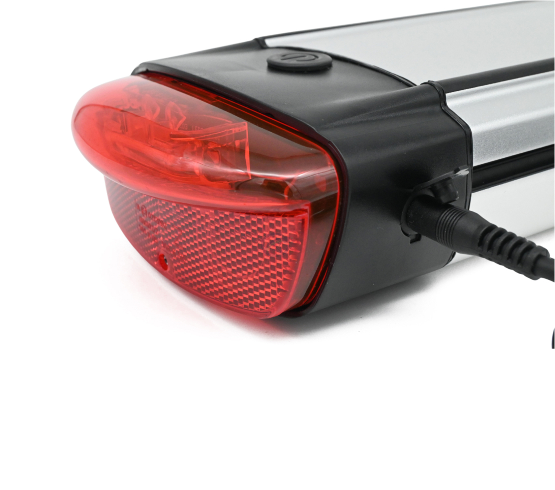 El cargador de la batería compatible con Gazelle Innergy Gold está enchufado en el lateral de la batería. La luz trasera es claramente visible.